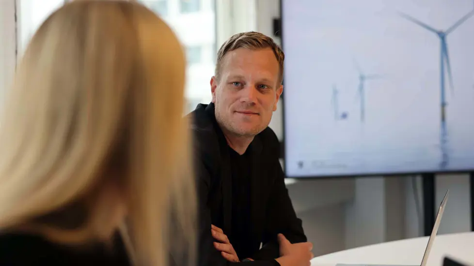 Mannlig ansatt ser på kvinnelig kollega som har ryggen mot kamera