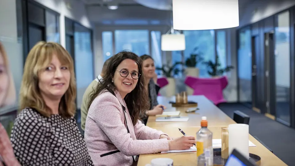 Kvinnelige ansatte ved siden av hverandre langs et bord.